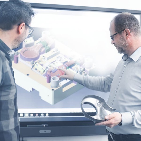 Two men watching a computer animation on a smartboard.